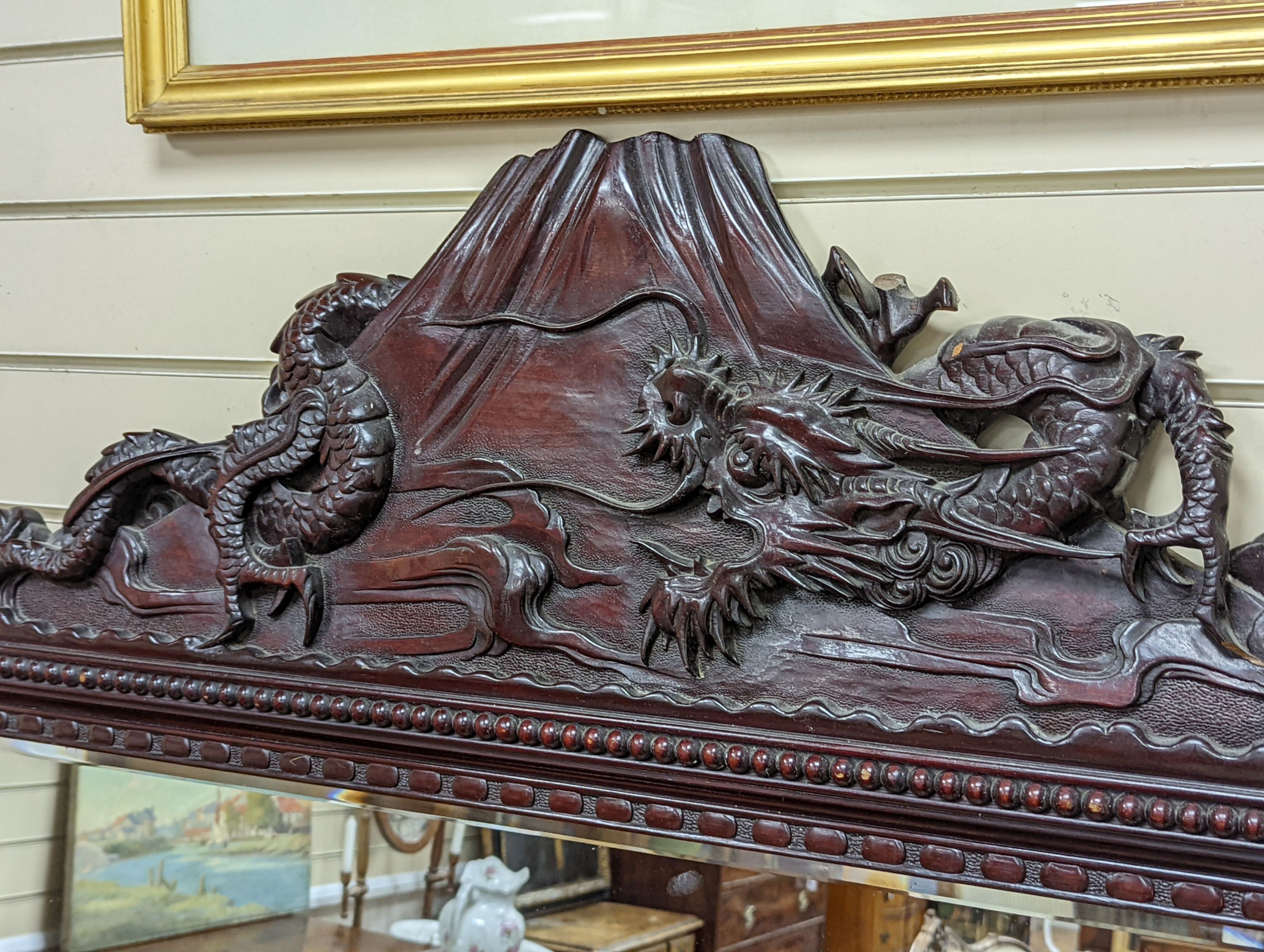 A Japanese carved hardwood dragon overmantel mirror, width 112cm, height 180cm